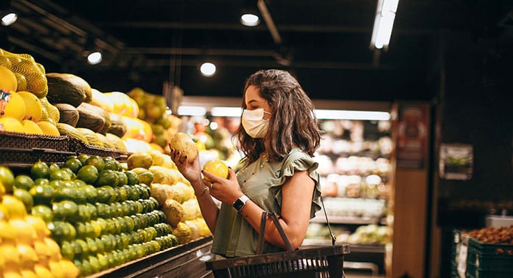 Woman shopping for fruits wearing mask