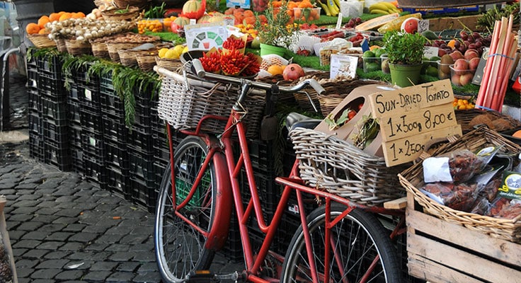 Bicycle and produce at vibrant market stall.